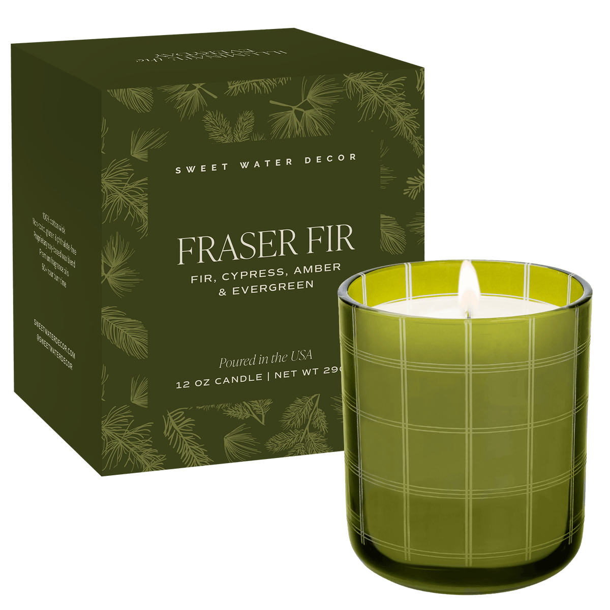 A lit 12 oz candle in a green glass jar with a white wick and flame, shown next to its dark olive green packaging box decorated with pine needle patterns. The brand Sweet Water Decor is visible on the box.