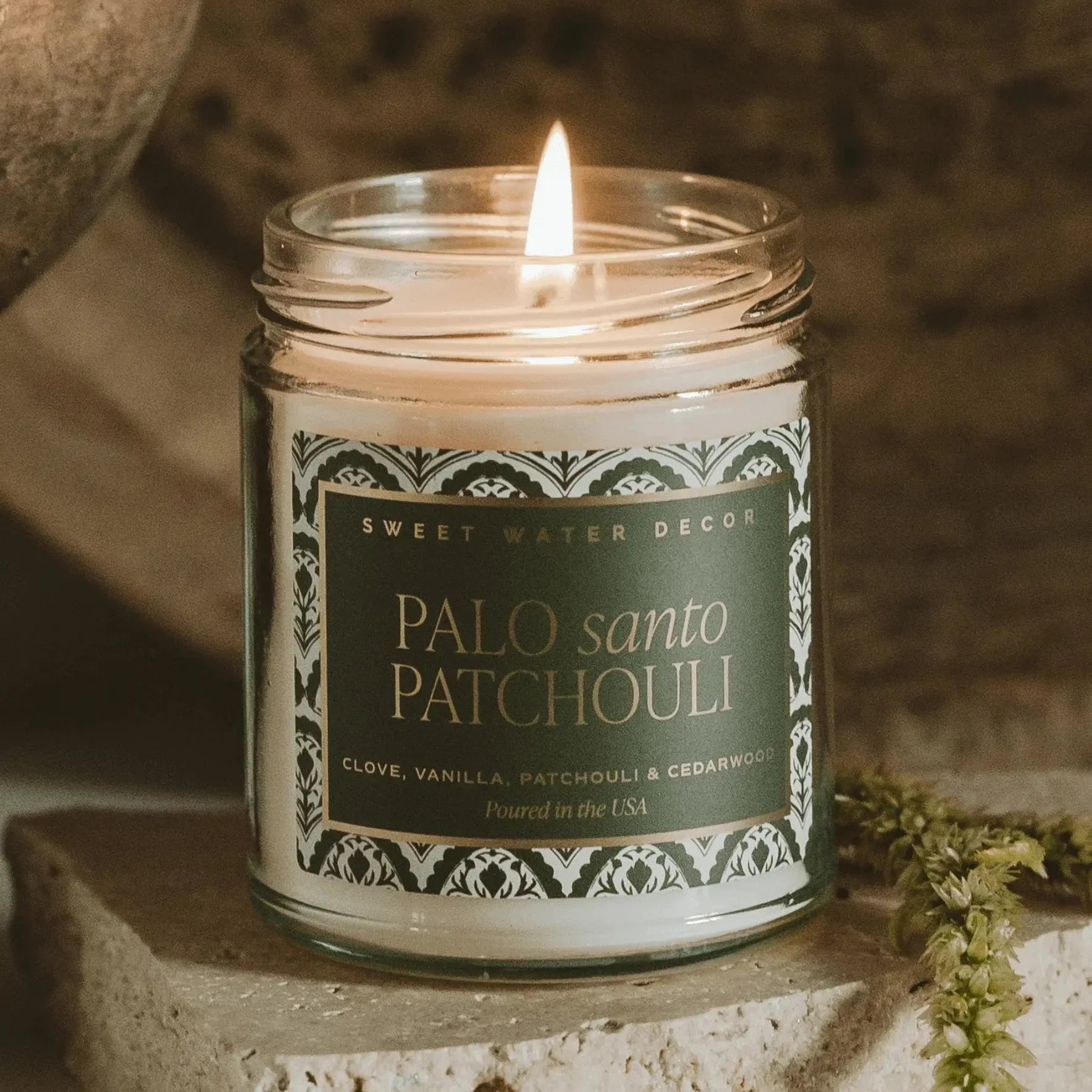 Palo Santo Patchouli candle with clove, vanilla, cedarwood scent, lit in cozy farmhouse decor setting