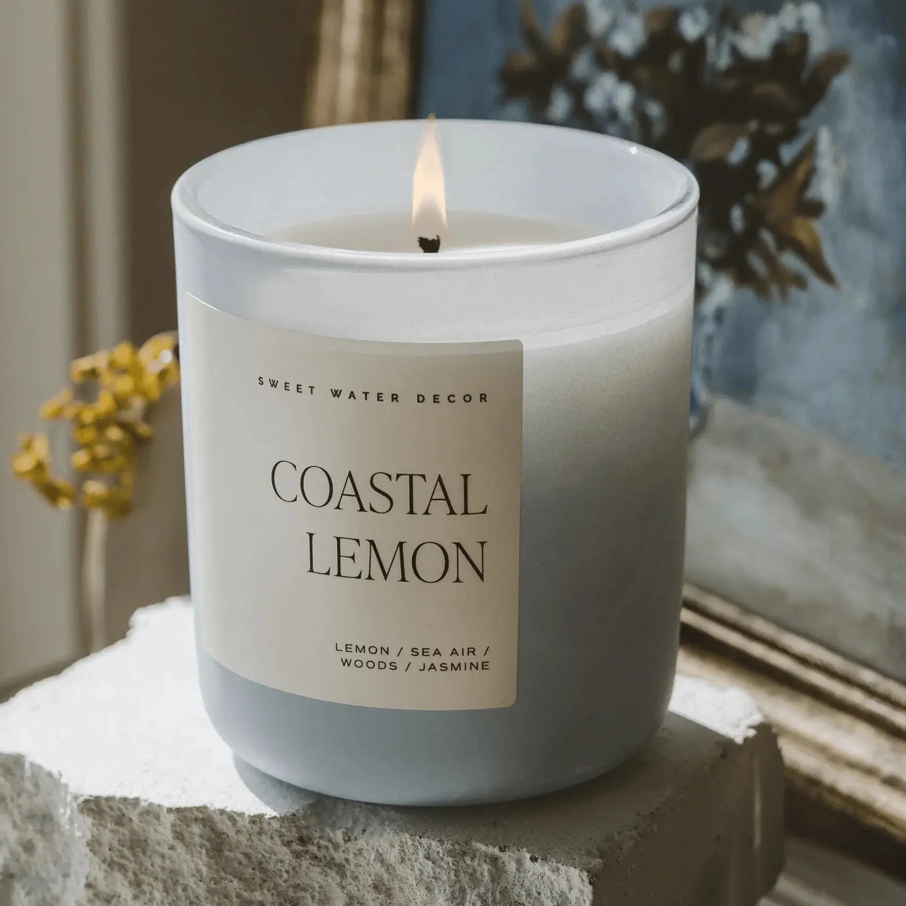 Coastal Lemon scented candle in frosted glass, lit, with farmhouse decor background