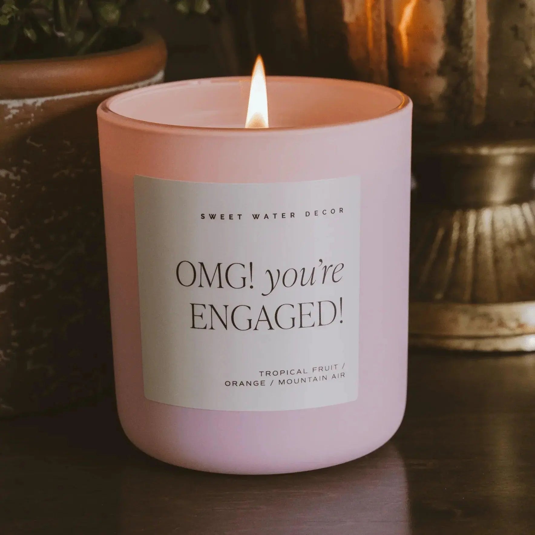 Pink engagement candle with 'OMG! you're ENGAGED!' label, tropical fruit scent, cozy home decor