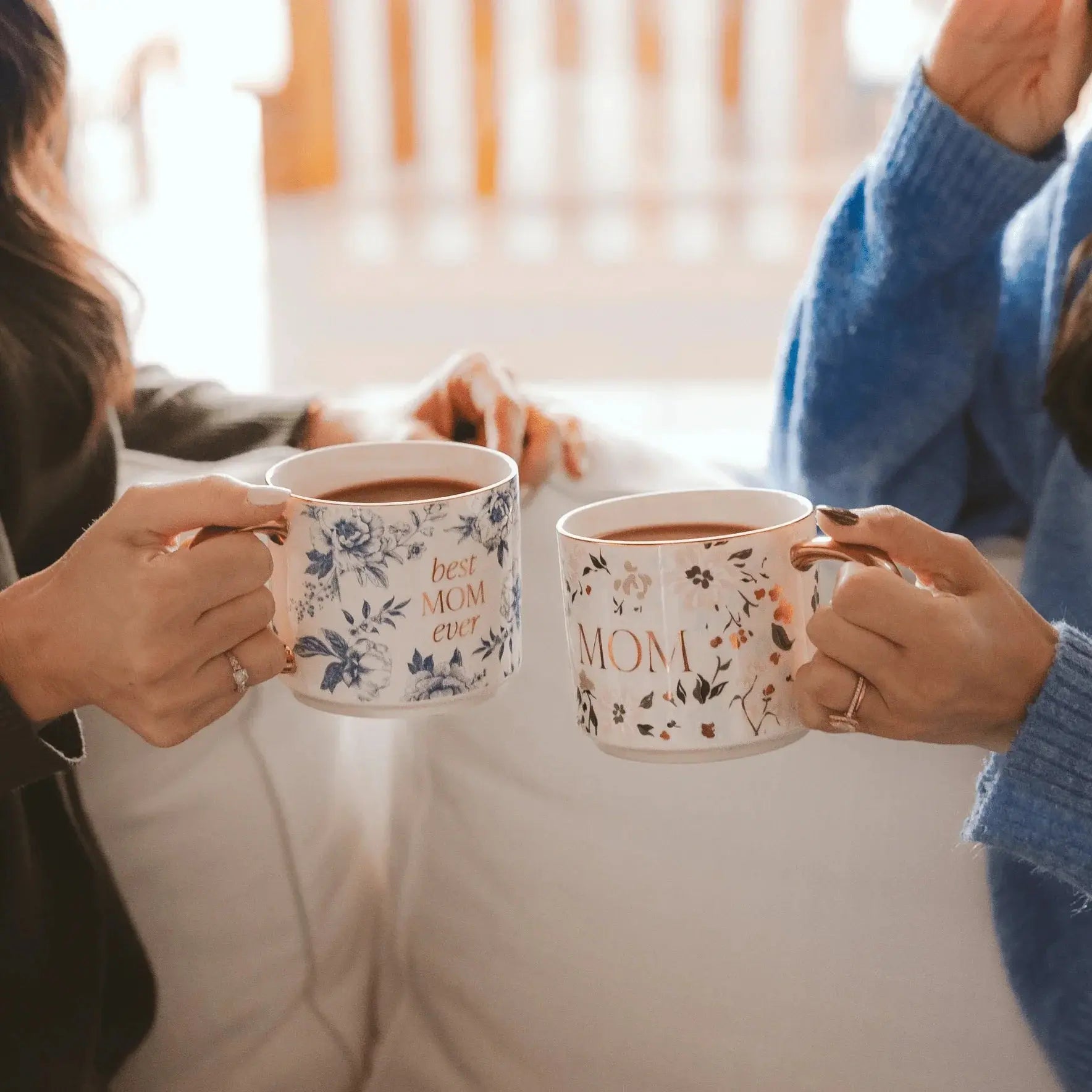 Two women holding floral 'Mom' mugs with rose gold handles, cozy home decor gift idea