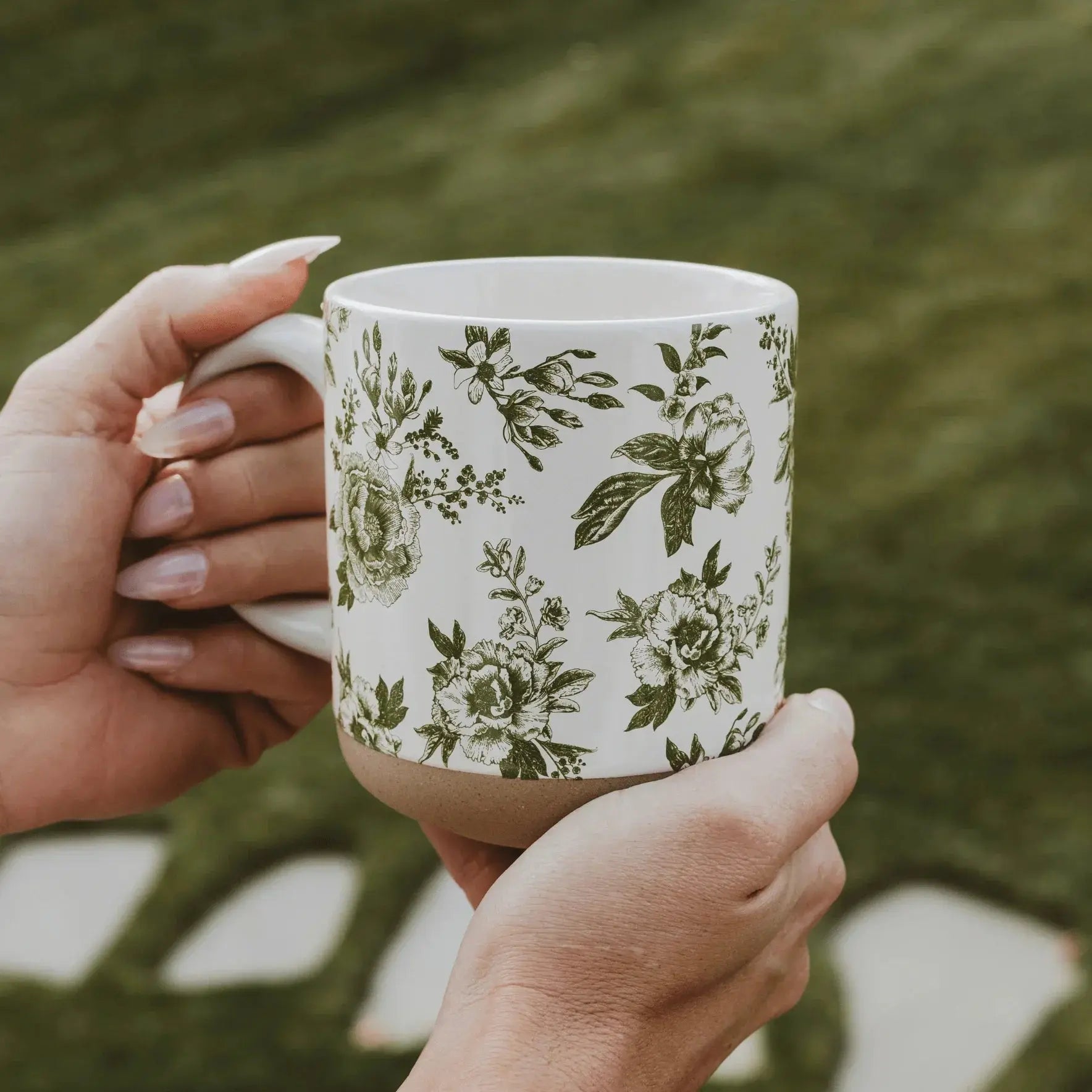 Floral patterned ceramic mug held in hands, perfect for cozy farmhouse decor