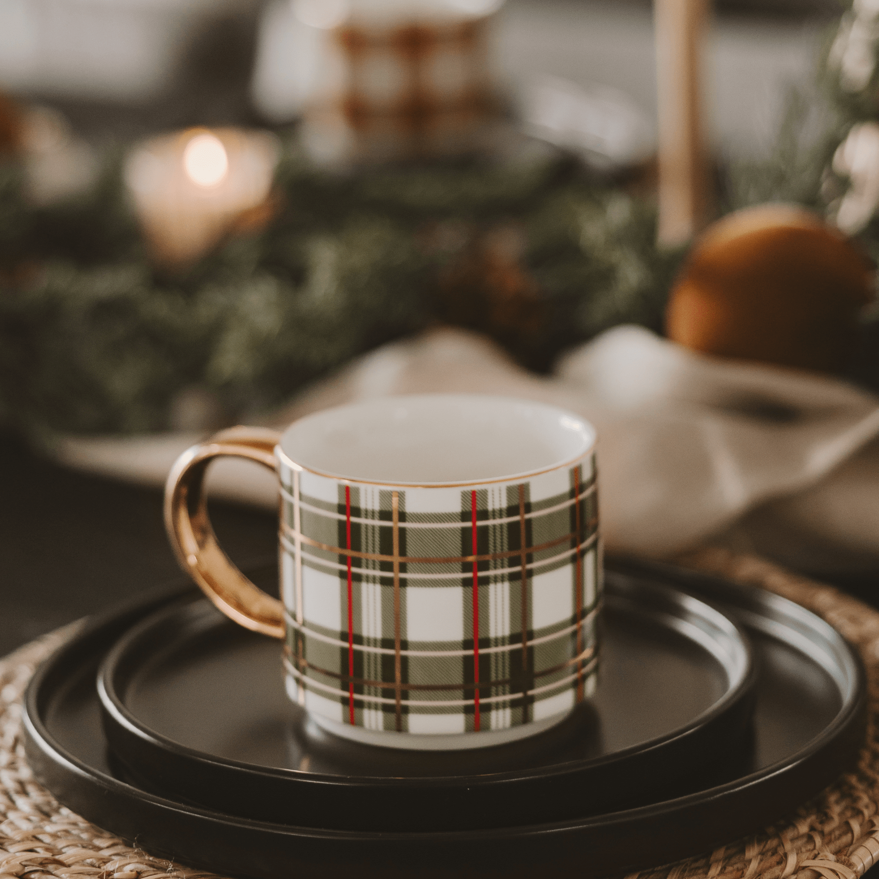Plaid mug on a black tray with a blurred festive background