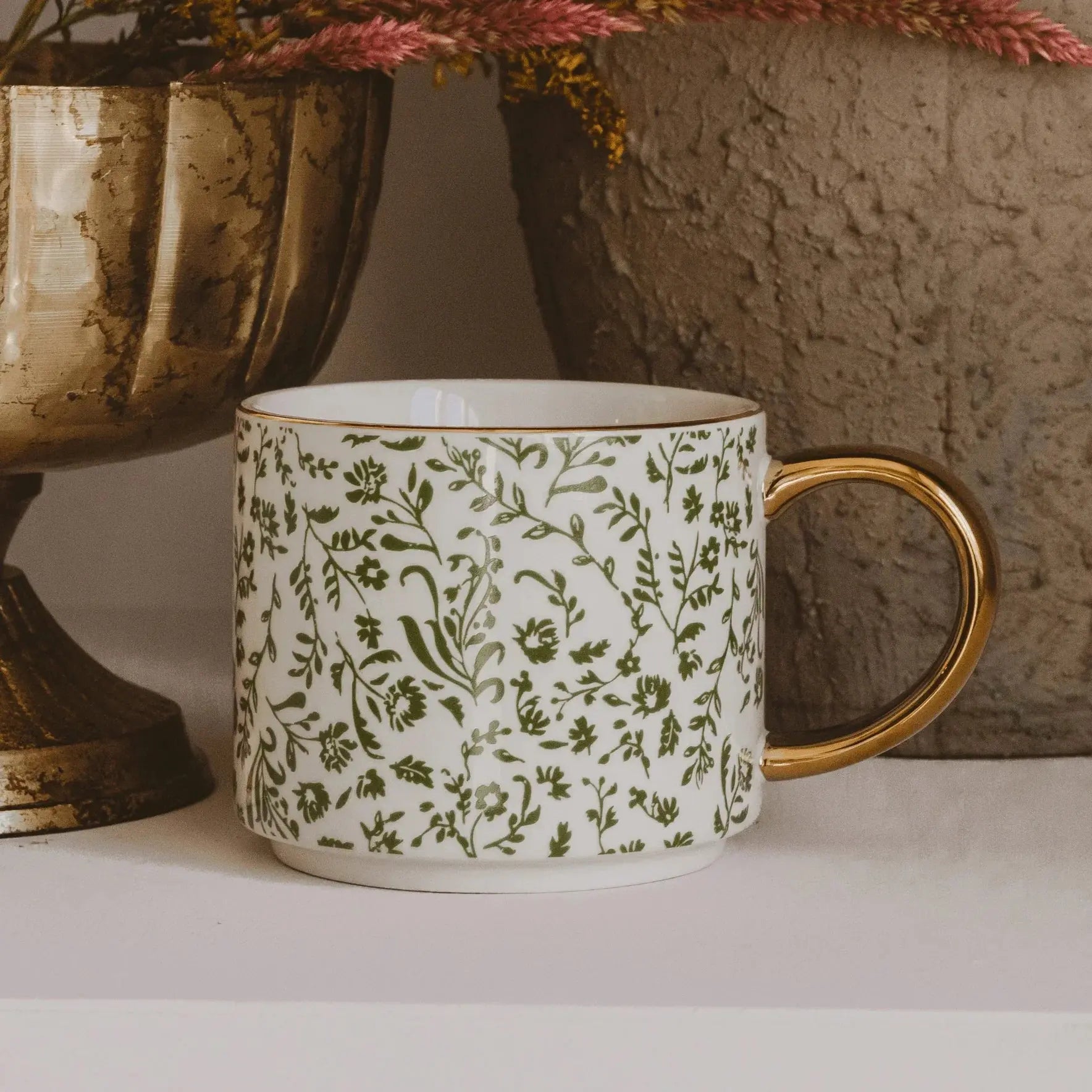 White ceramic mug with green floral pattern and gold handle, farmhouse decor style