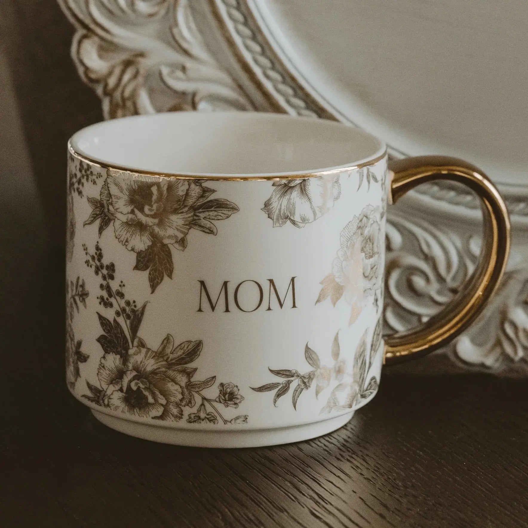 Elegant 'MOM' mug with gold trim and floral design, perfect for cozy farmhouse home decor and thoughtful gifts.