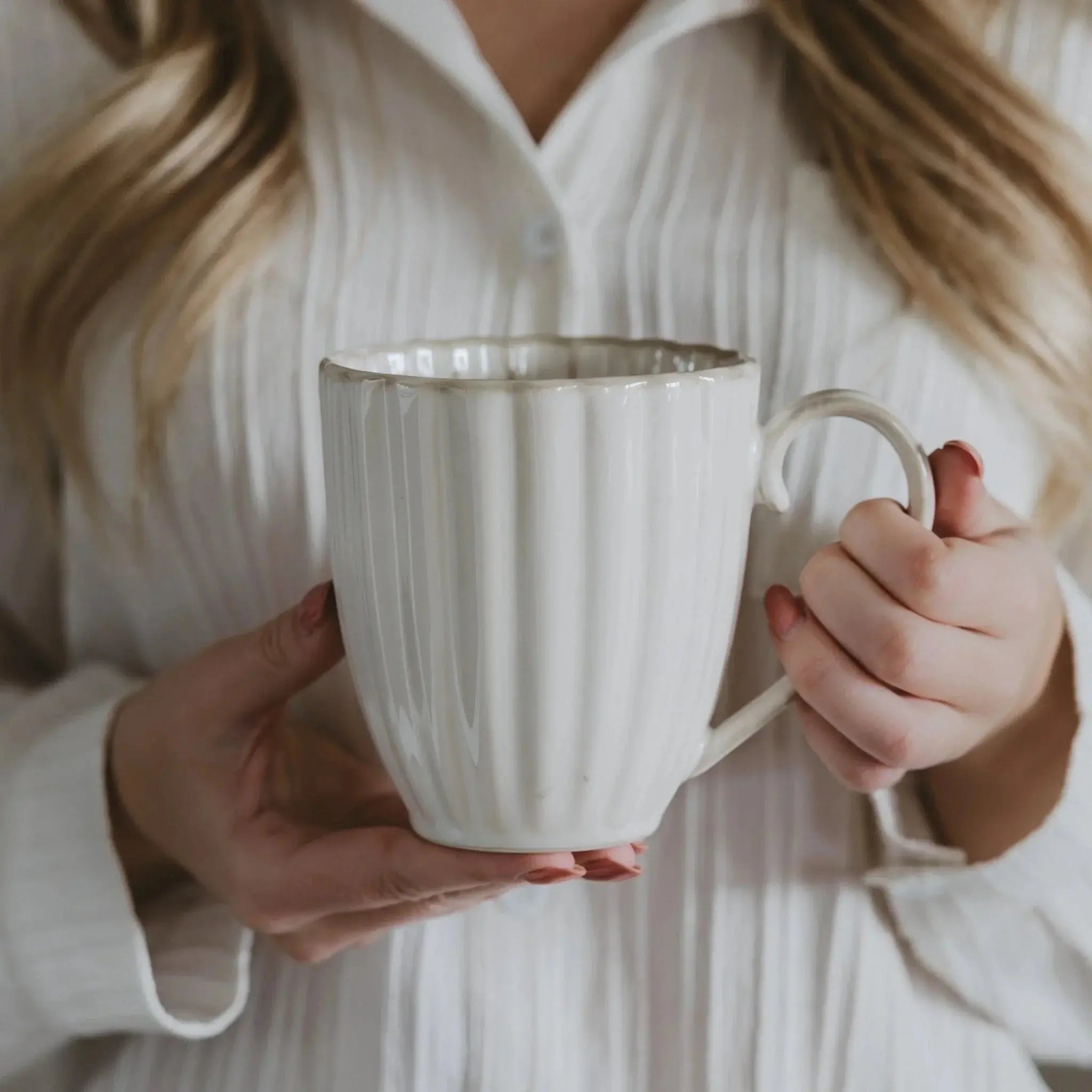 Cozy farmhouse ceramic mug with ribbed texture, held by woman in white shirt for warm home decor