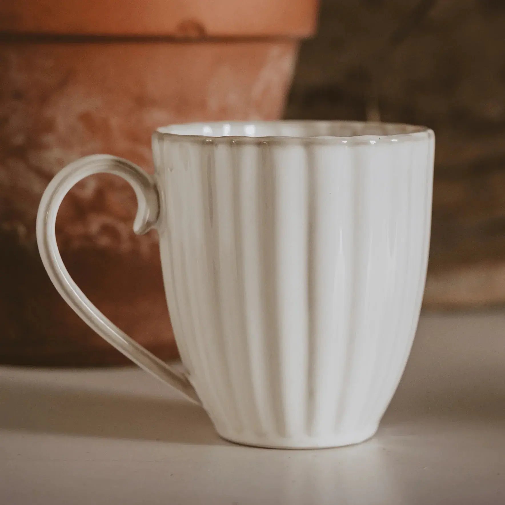 White ribbed ceramic mug with heart-shaped handle, cozy farmhouse kitchen decor