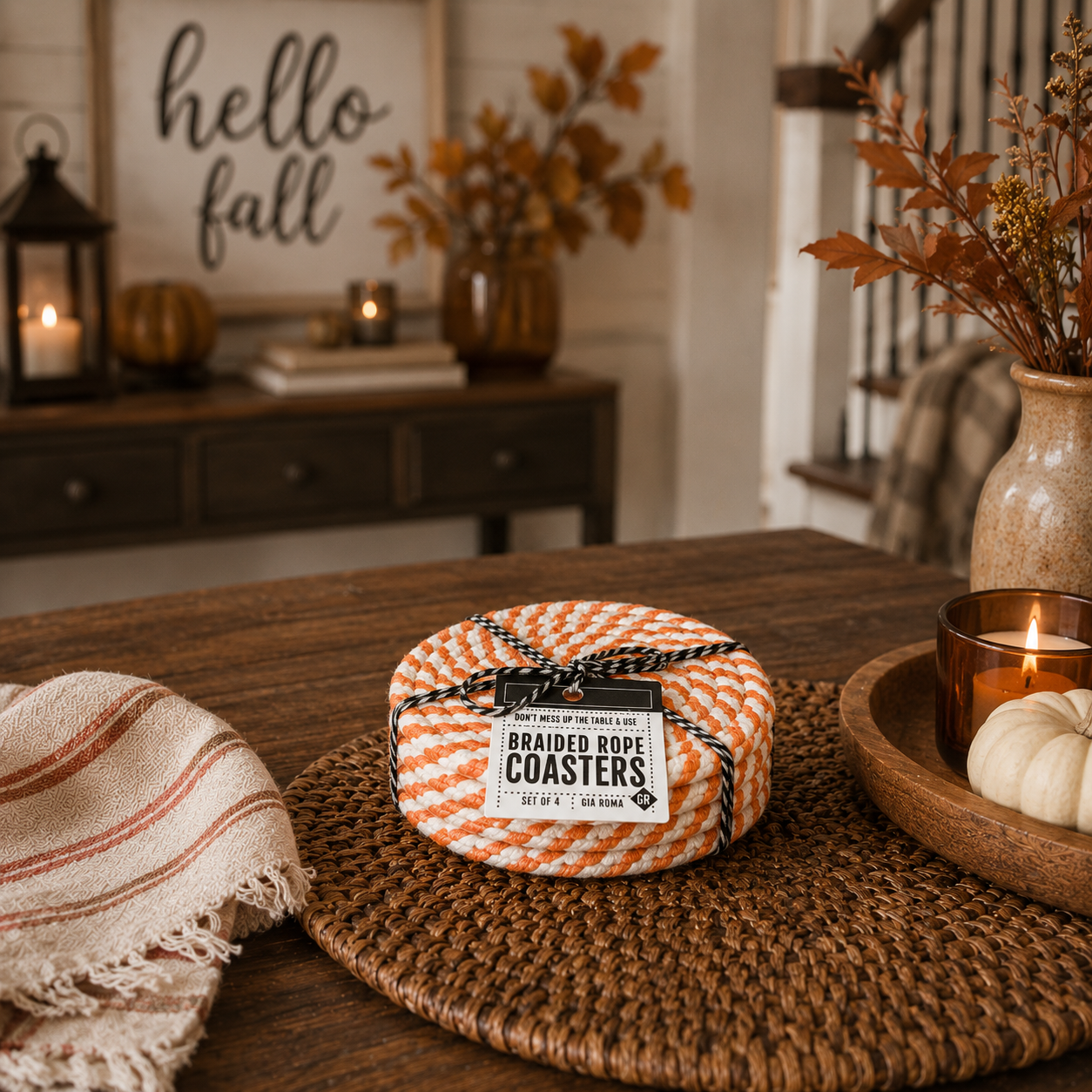 Braided rope coasters on a table with fall decorations in the background