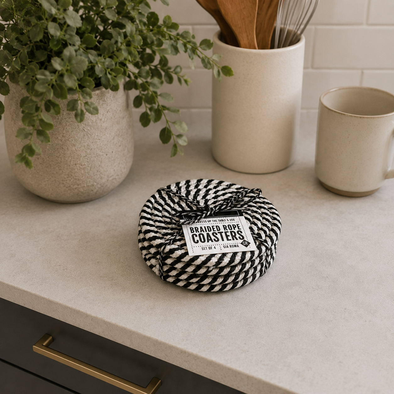 Braided rope coasters on a kitchen counter with a plant and utensils in the background.