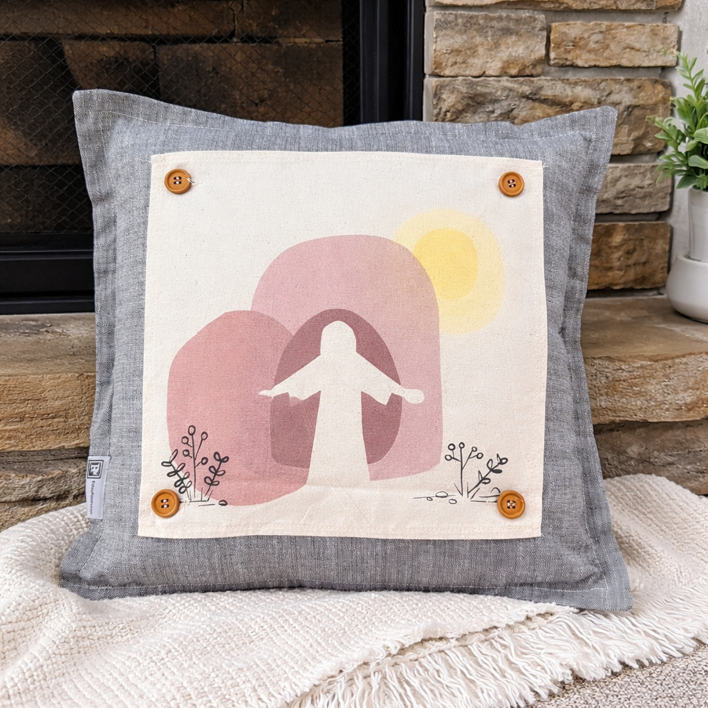 Decorative pillow with a silhouette design of a person, pink shapes, and a yellow sun on a stone fireplace background.