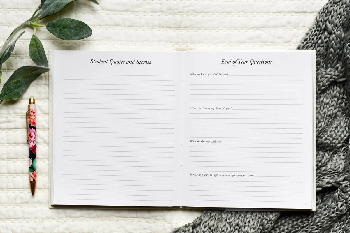 Notebook with lined pages on a textured surface with a pen and leaves.