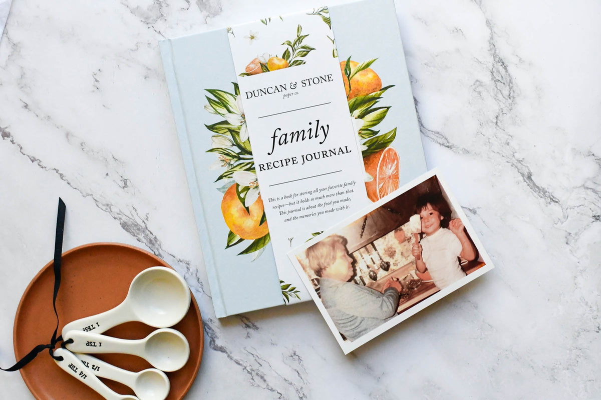 Family recipe journal with decorative cover and photo on a marble surface