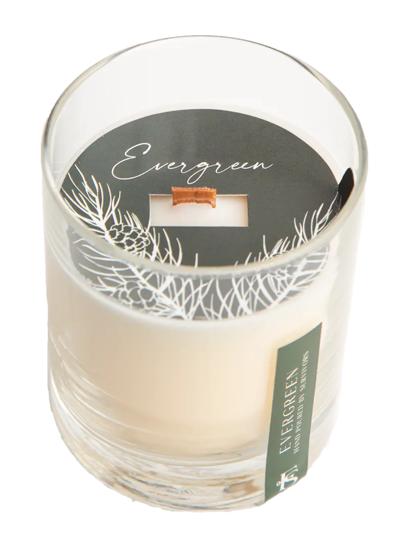 Candle in a glass jar with 'Evergreen' label on a white background
