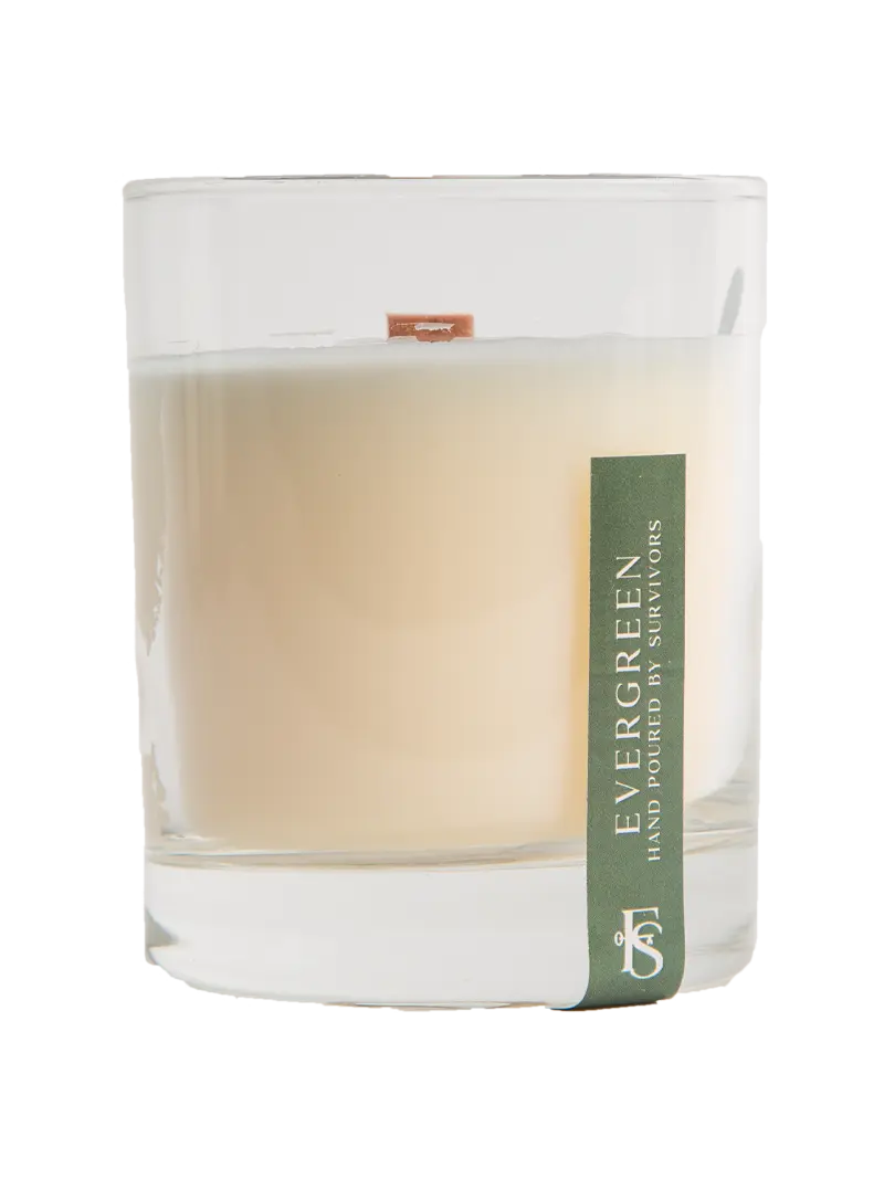Candle in a glass jar with 'Evergreen' label on a white background