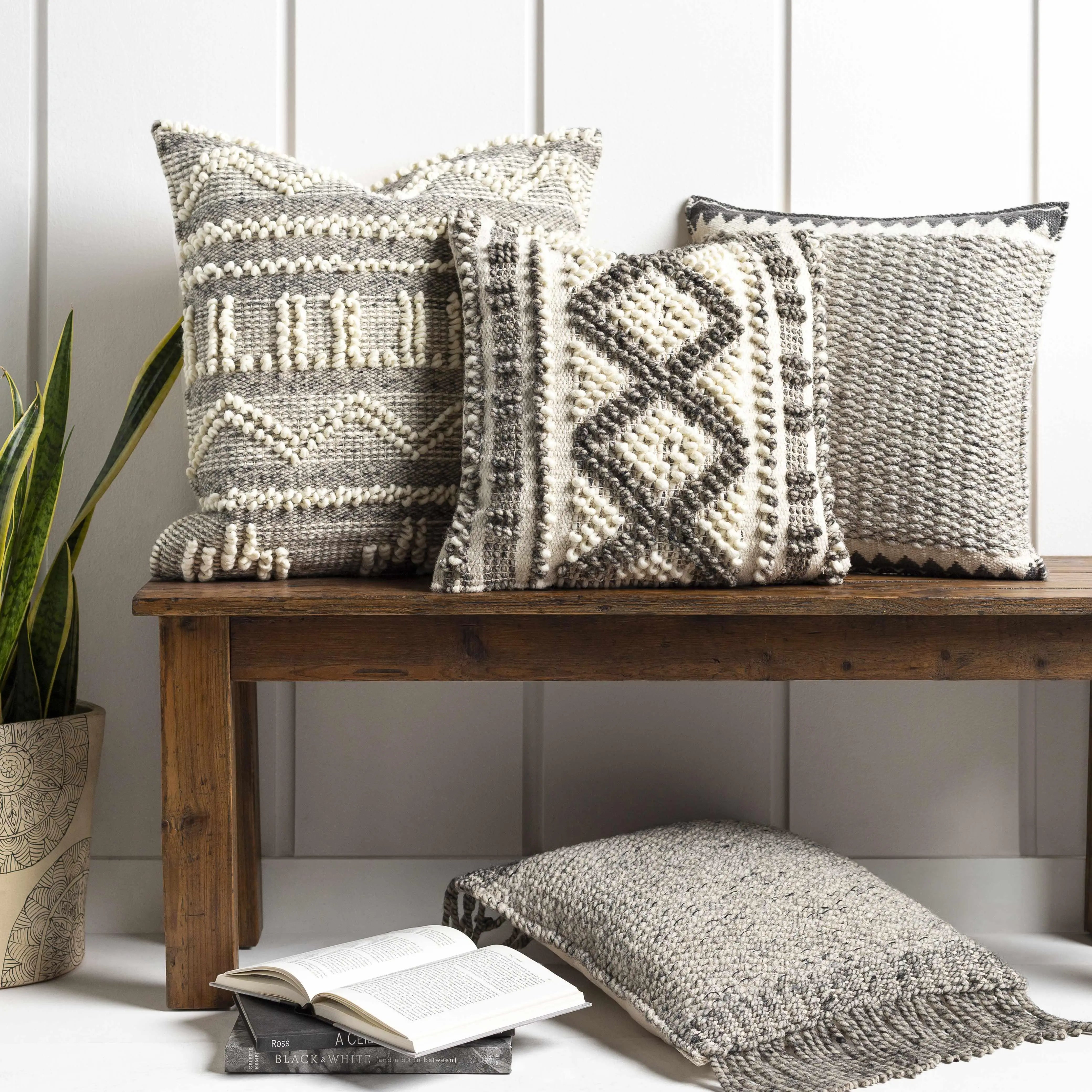 Cozy farmhouse throw pillows with textured patterns on rustic wooden bench