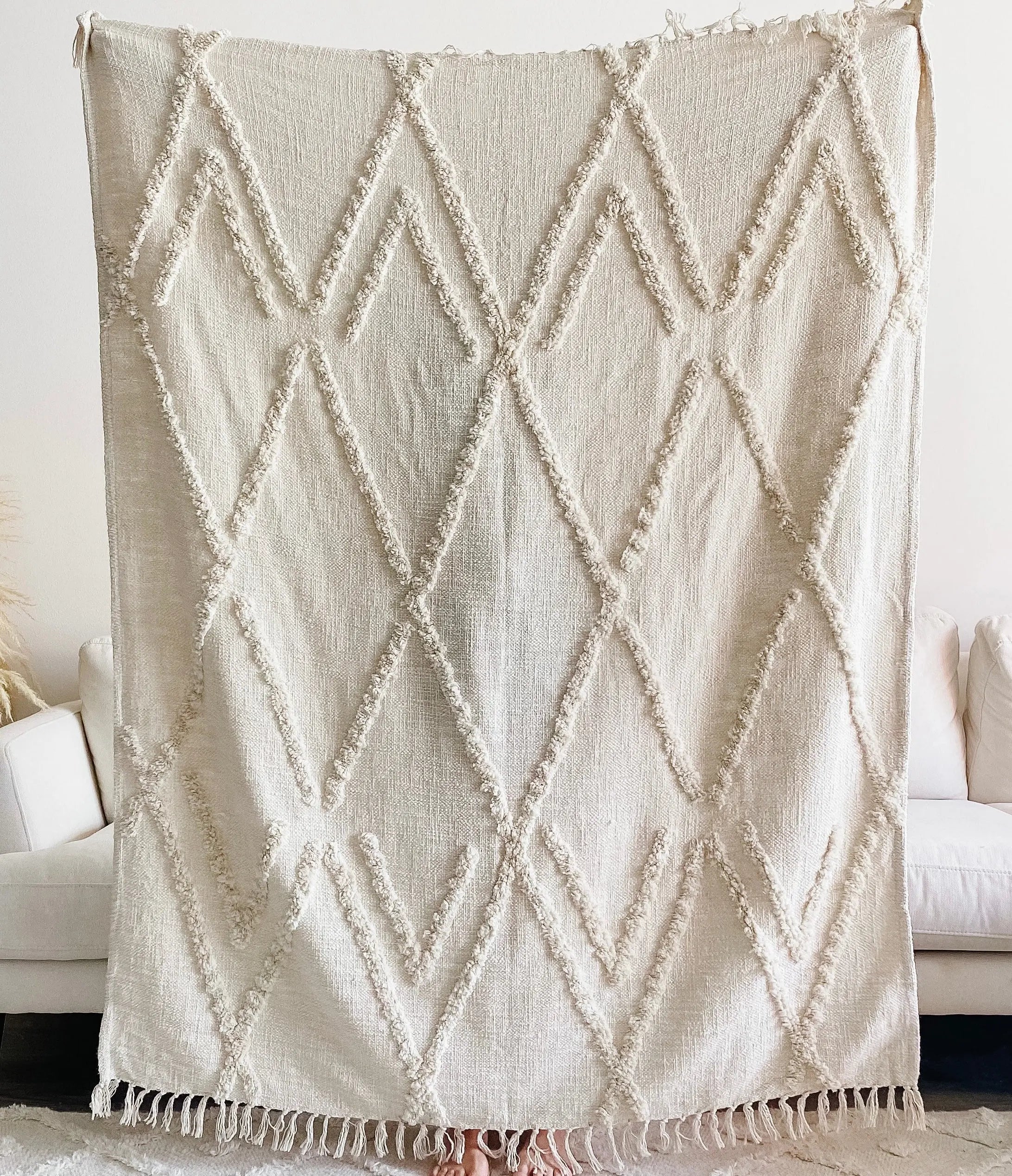 Cream boho throw blanket with geometric diamond pattern and fringe, cozy farmhouse decor