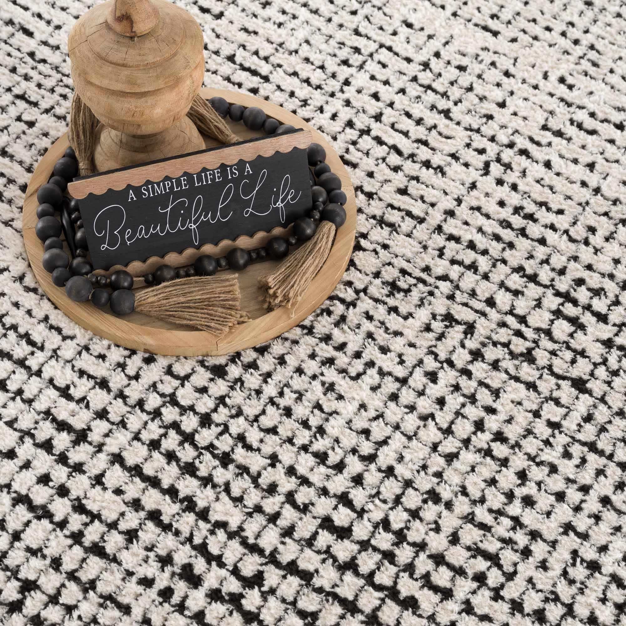 Cozy farmhouse decor with wooden sign reading 'A Simple Life Is A Beautiful Life' on patterned rug