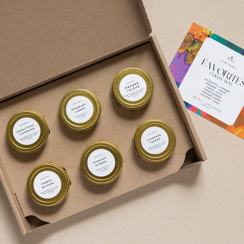 Set of small jars with gold lids in a cardboard box, with a card on the side.