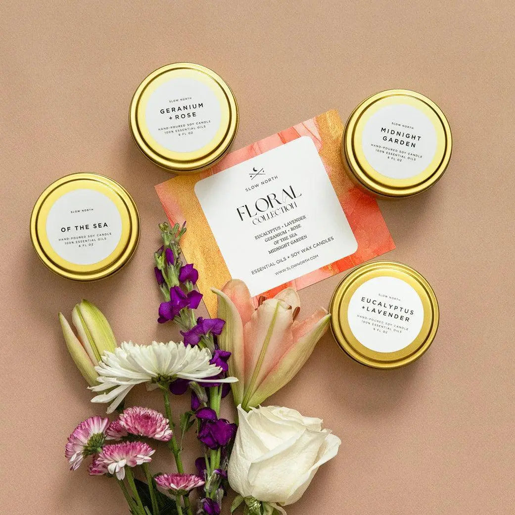 Floral collection soy candles with essential oils, gold tins, and fresh flowers for cozy home decor
