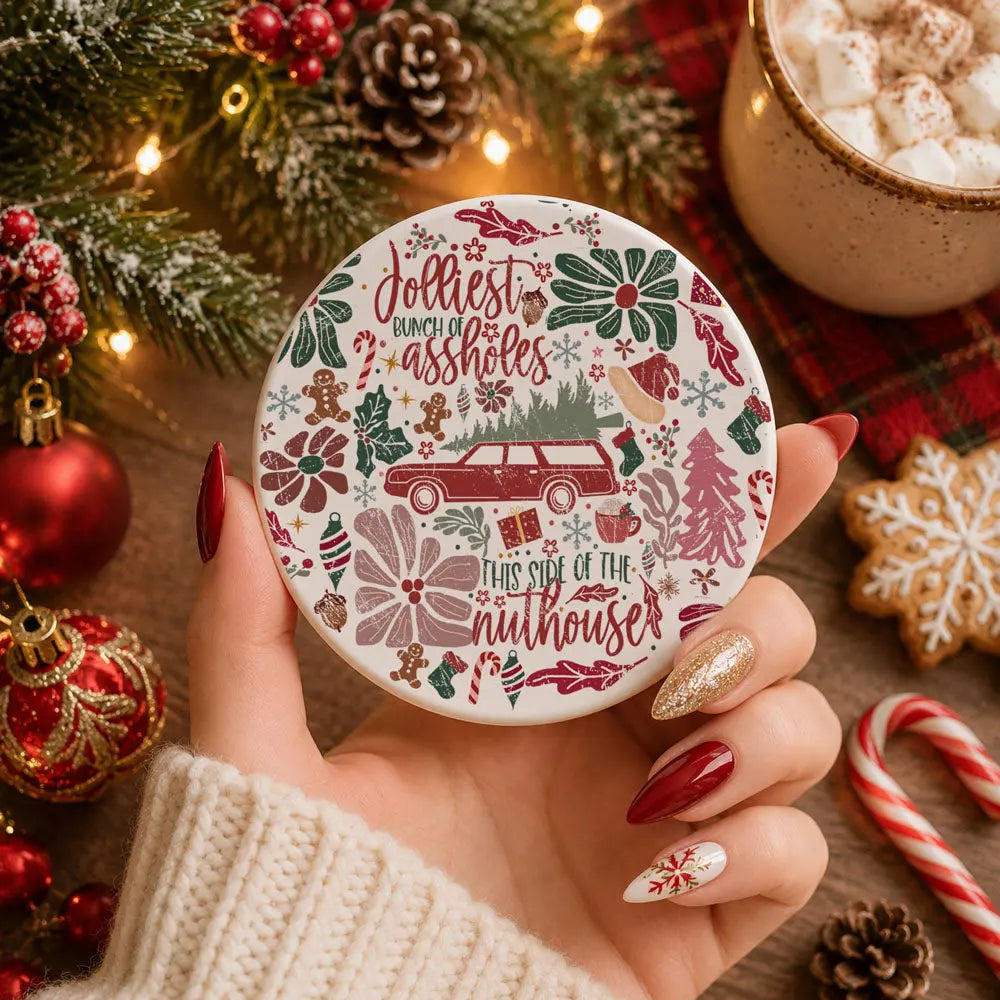 Decorative coaster with Christmas-themed design held by a hand, surrounded by festive items.