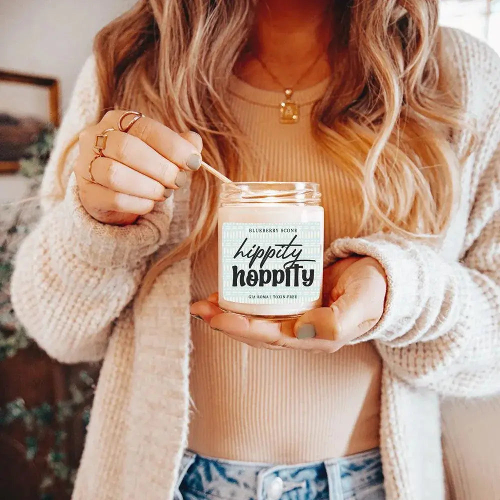 Person holding a 'hippity hippity' candle with a neutral background