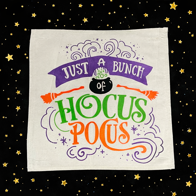 Halloween-themed towel with colorful text and graphics on a black background with stars.
