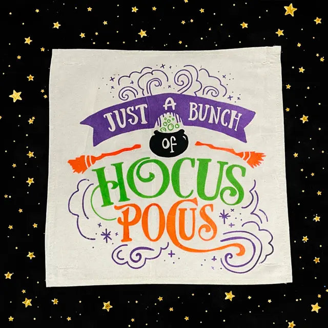 Halloween-themed towel with colorful text and graphics on a black background with stars.