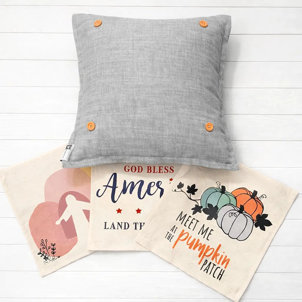 Gray pillow with orange buttons on a white wooden surface, with two decorative bags featuring text and graphics.