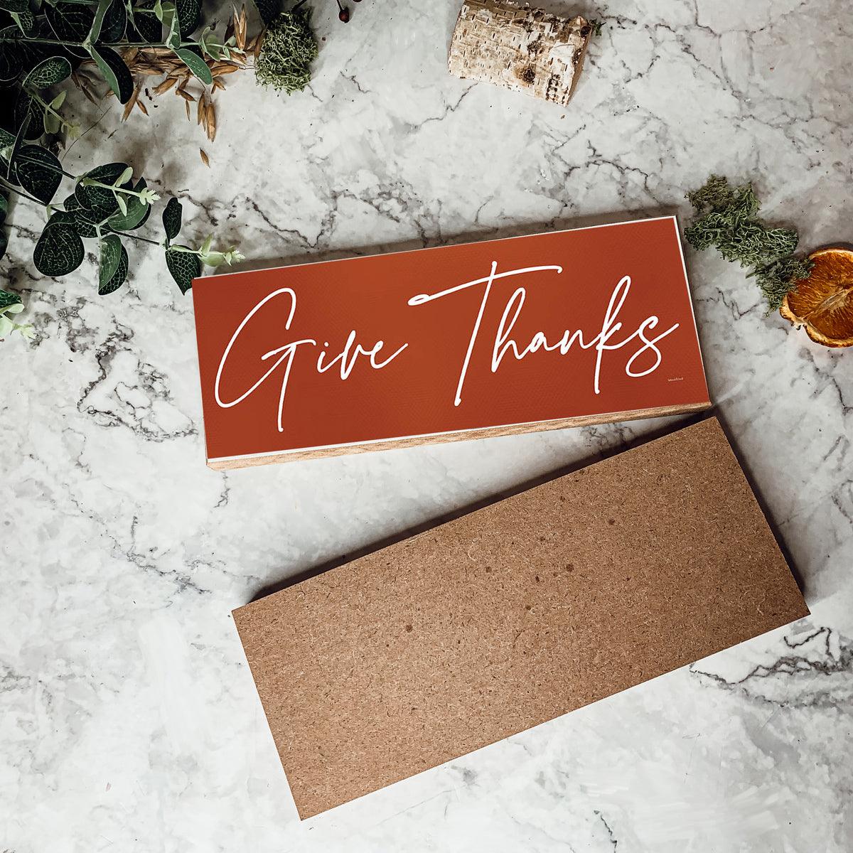 Card with 'Give Thanks' text on a marble surface with decorative elements