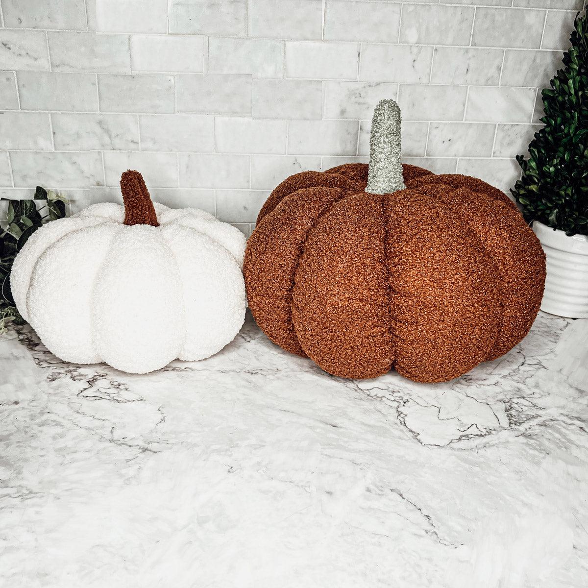 Decorative pumpkins on a marble surface with a white brick wall background