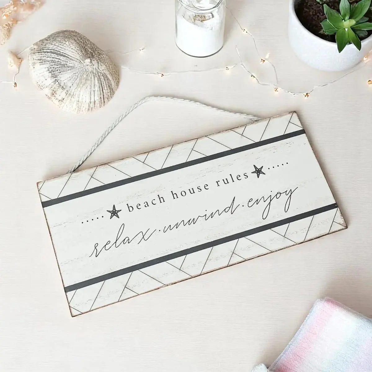 Beach house rules sign with relax unwind enjoy text, coastal decor with starfish and fairy lights
