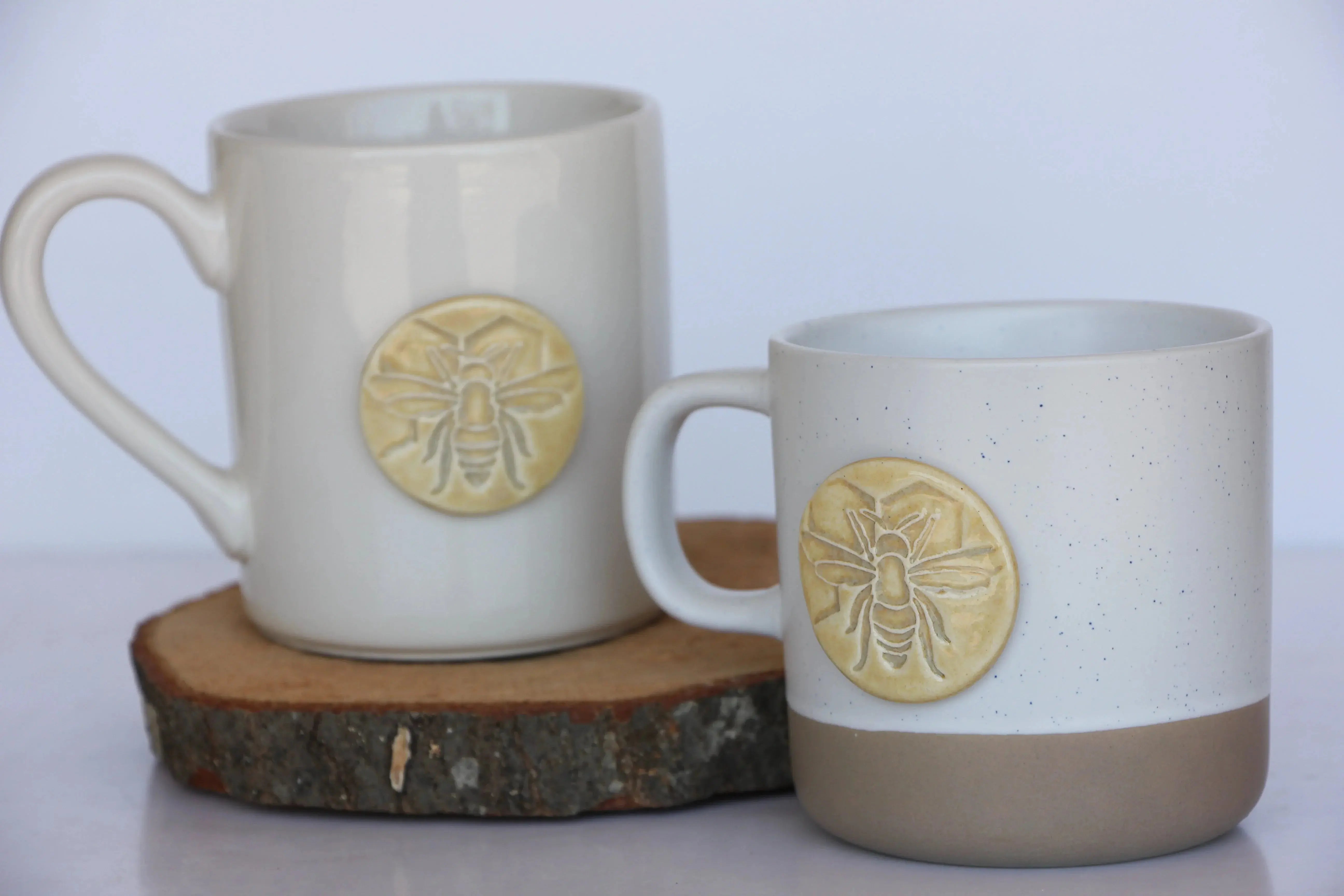 Farmhouse-style ceramic mugs with bee designs, cozy cottage decor