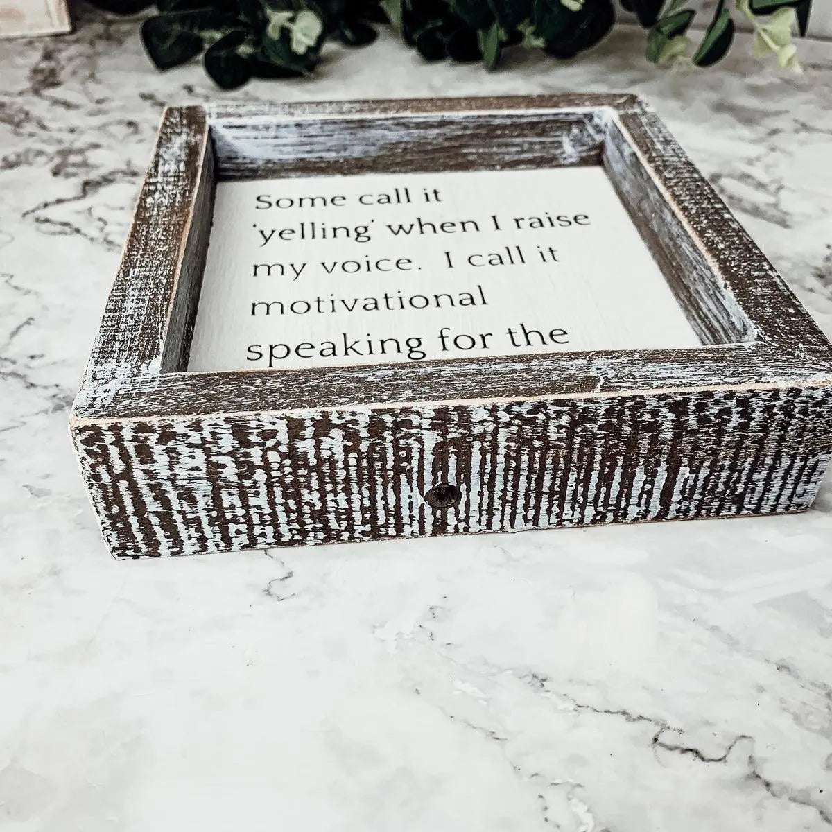 Wooden box with a motivational quote on a marble surface