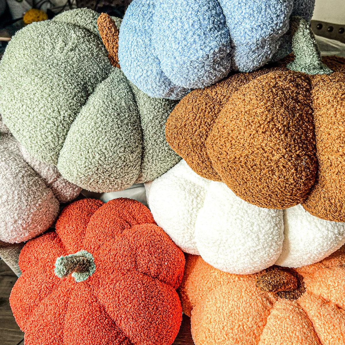 Collection of textured pumpkins in various colors on a wooden surface.