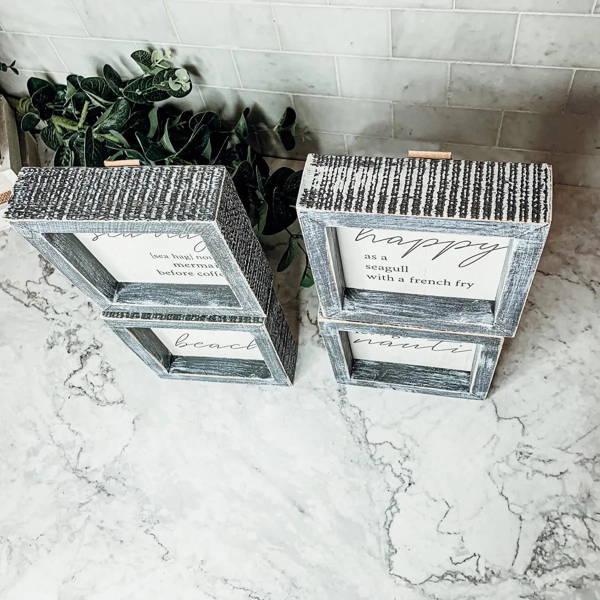 Decorative wooden boxes with printed text on a marble surface