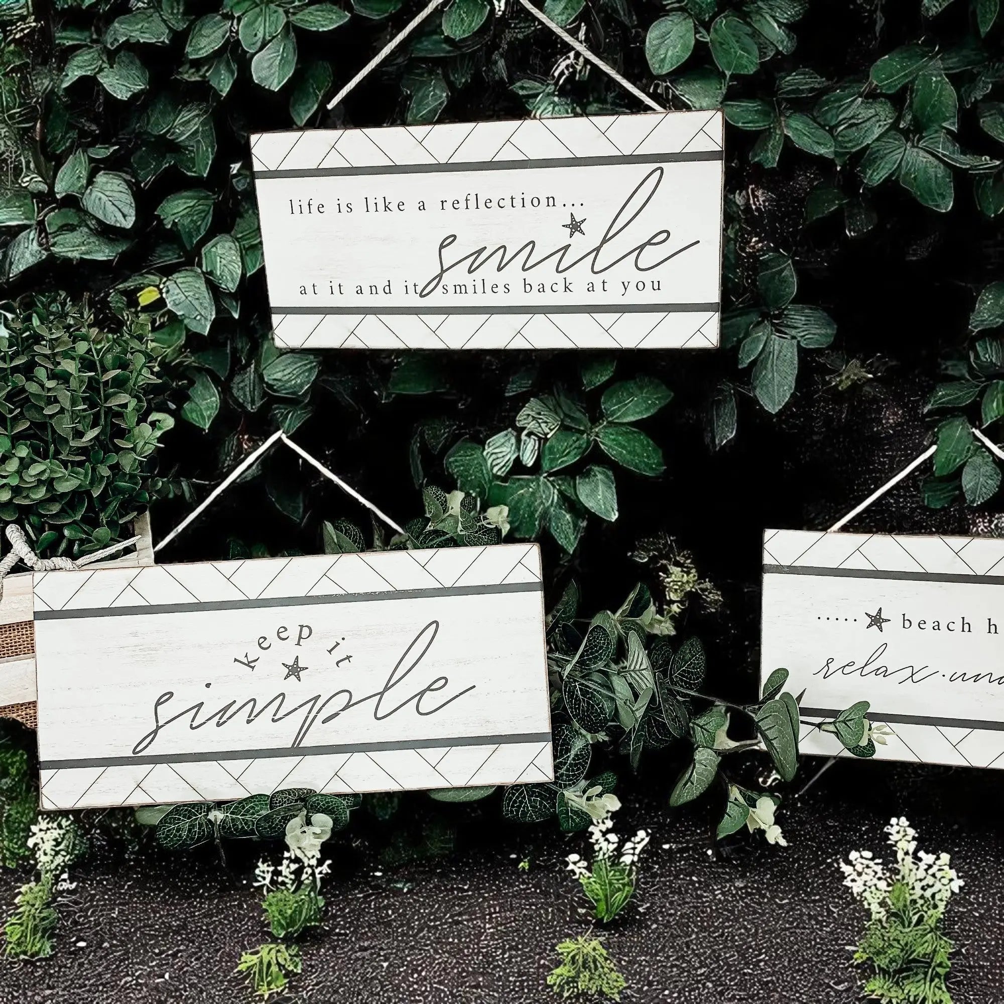Cozy farmhouse signs with inspirational quotes like 'smile' and 'keep it simple' amidst greenery
