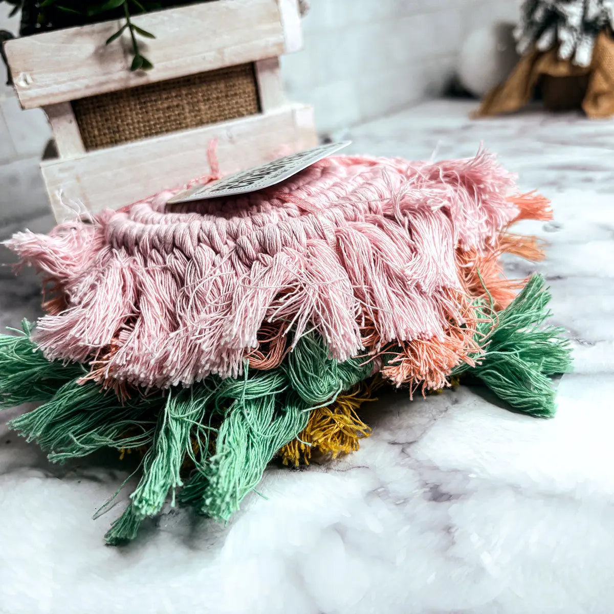 Stack of colorful textured pillows on a marble surface