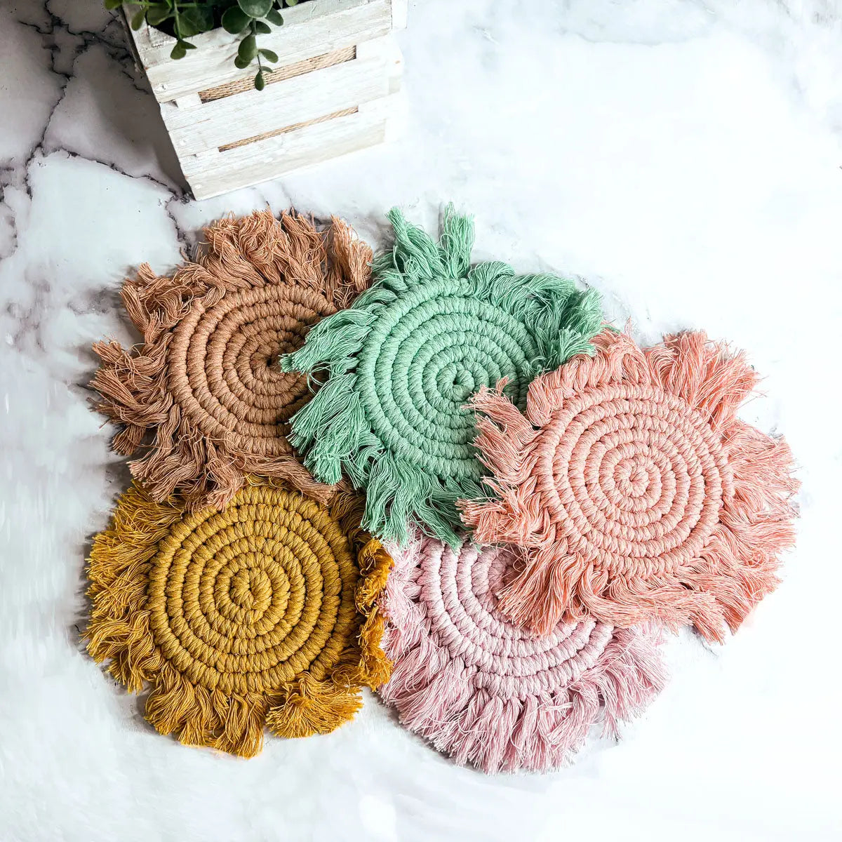 Set of colorful woven coasters on a marble surface