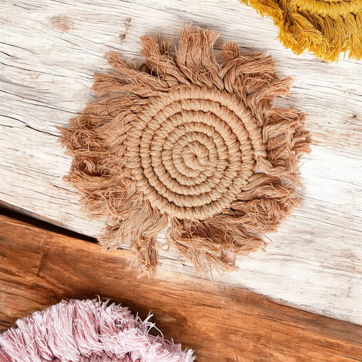 Round woven mat with frayed edges on a wooden surface