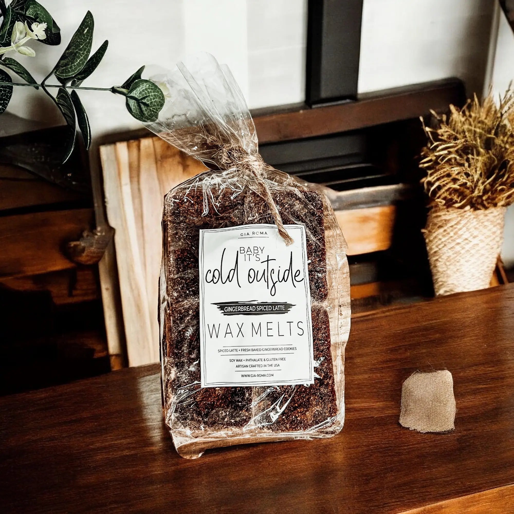 Packaged wax melts labeled 'Cold Outside' on a wooden surface with decorative plants.