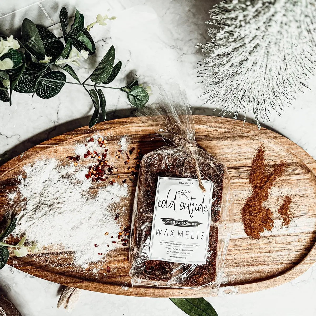 Packaged wax melts on a wooden tray with decorative elements