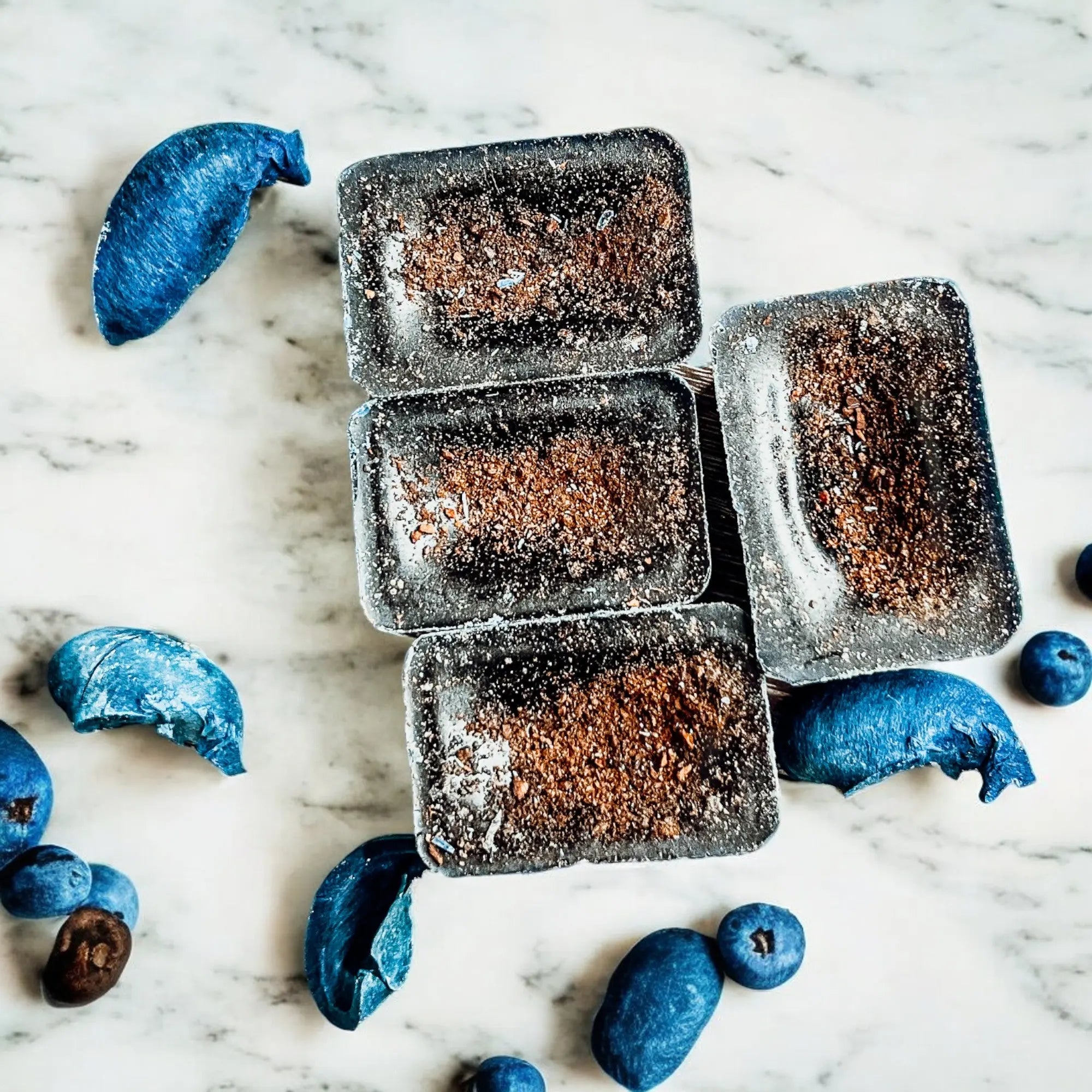Dark brown rectangular bars with blueberries on a marble surface