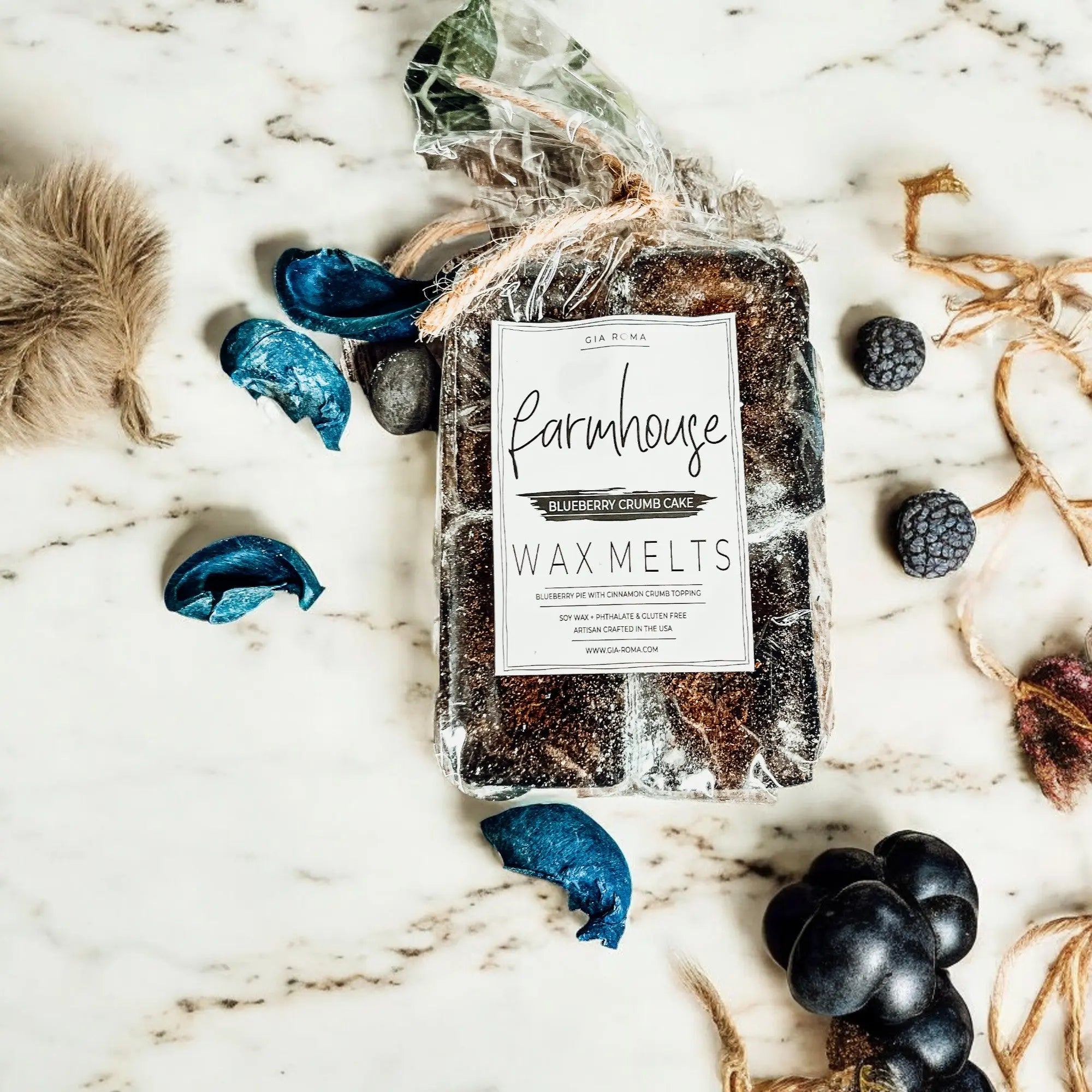 Pack of Farmhouse Wax Melts on a marble surface with decorative elements.