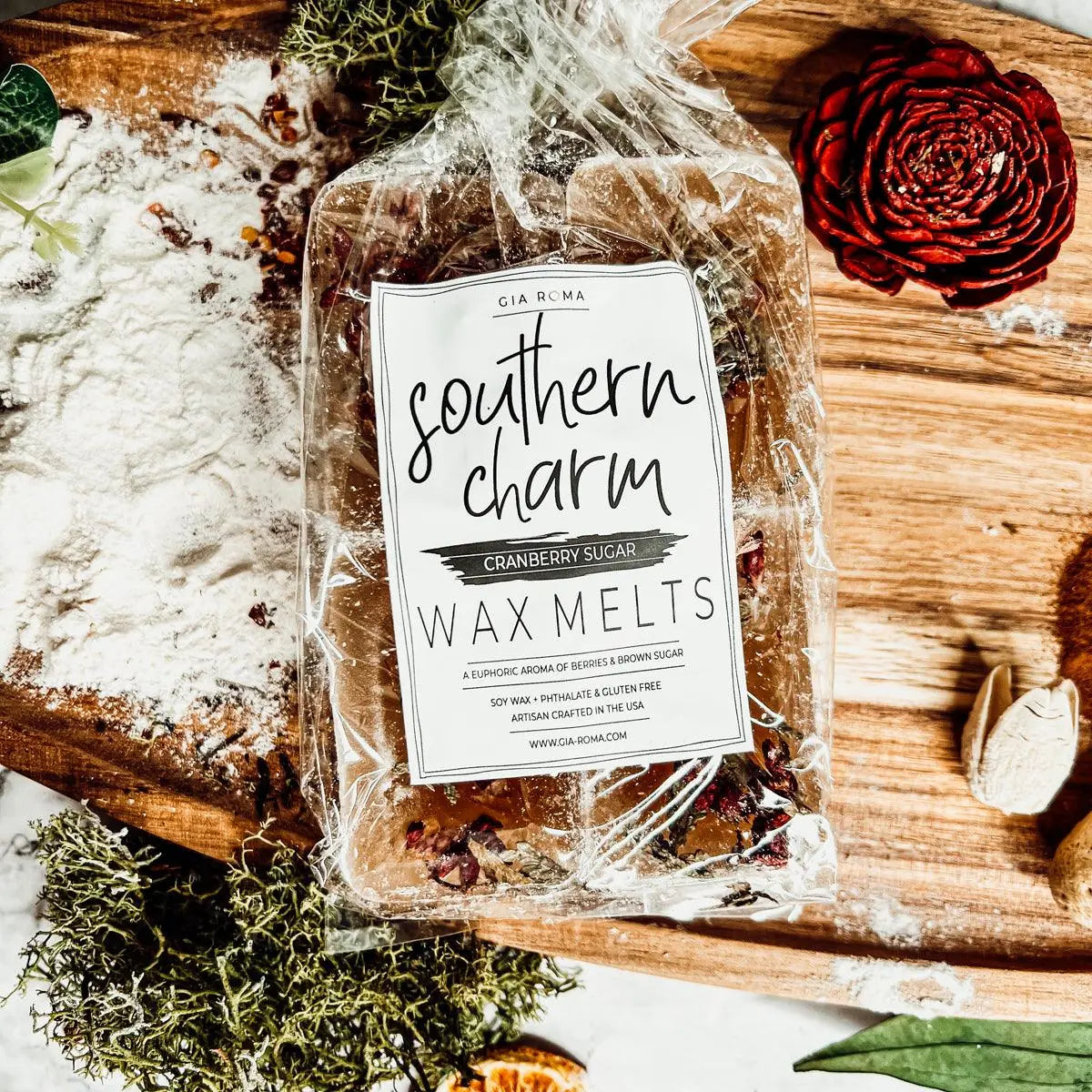 Packaged wax melts labeled 'Southern Charm' on a wooden surface with decorative elements.