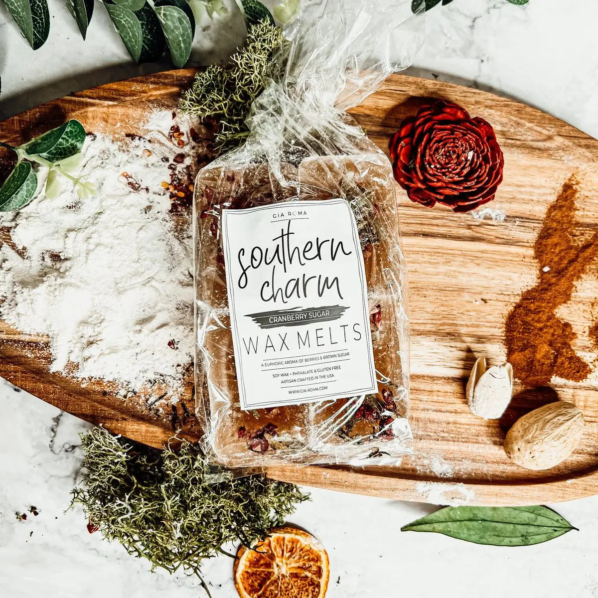 Packaged wax melts labeled 'Southern Charm' on a wooden board with decorative elements.