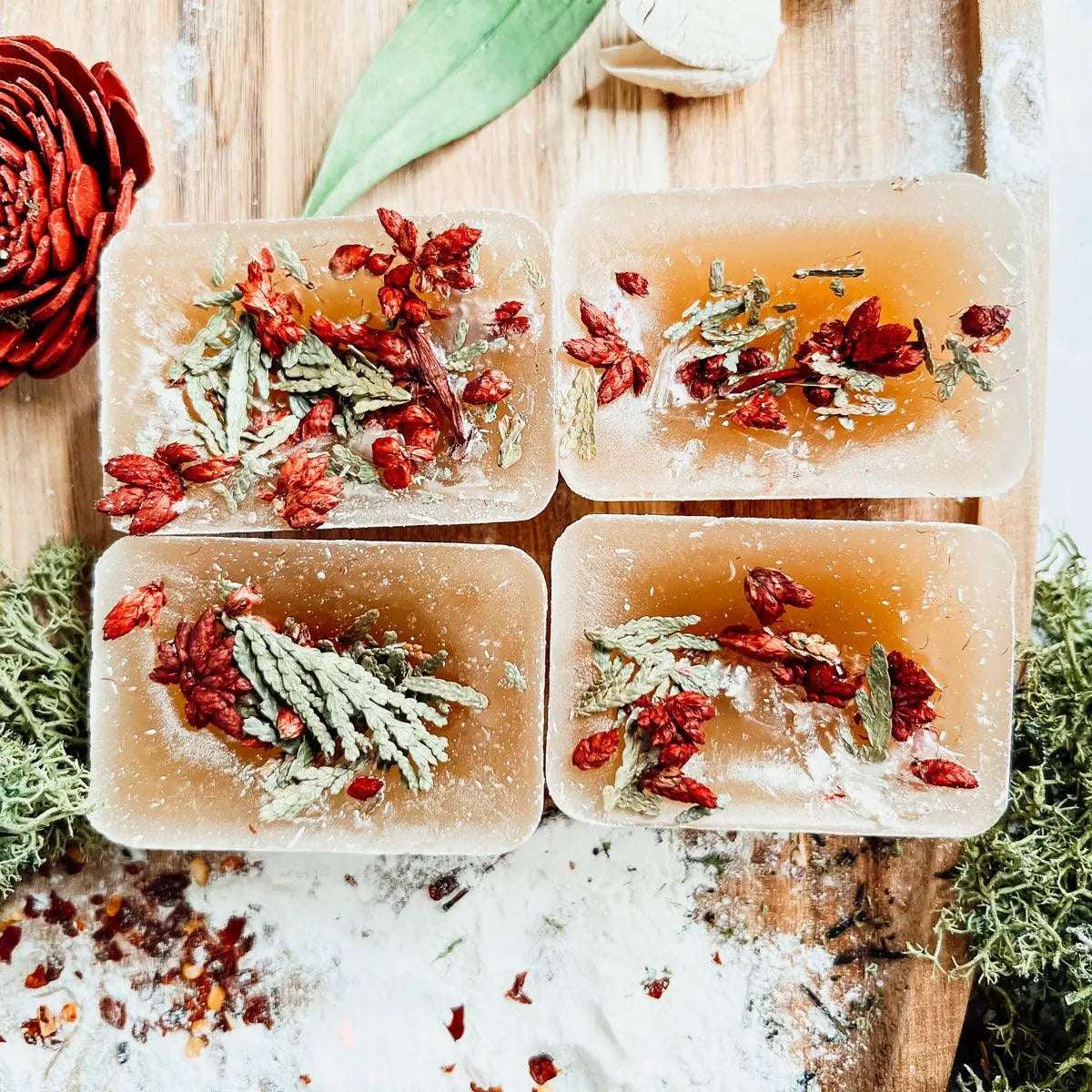 Four soap bars with natural ingredients on a wooden surface