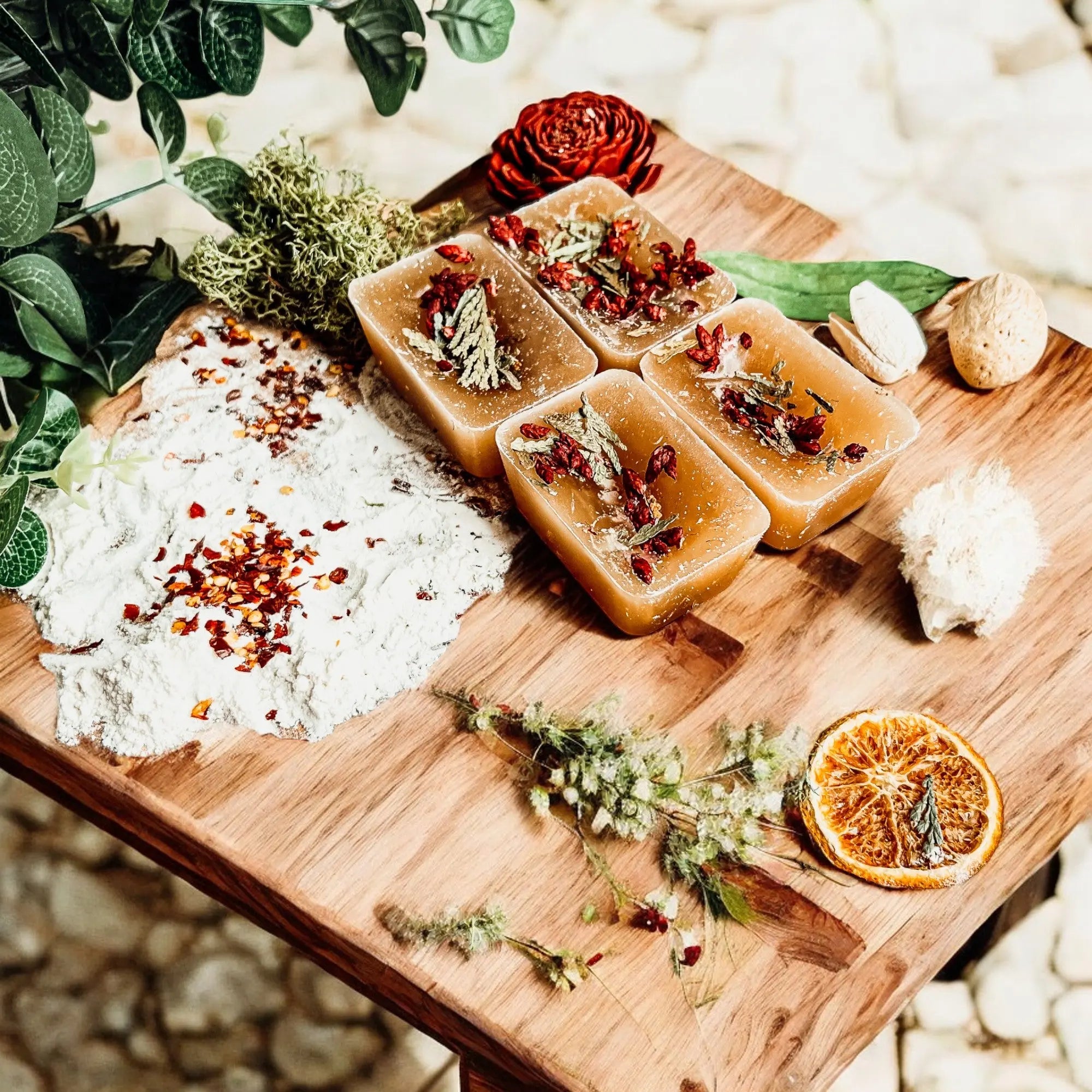 Wooden board with soap bars and natural ingredients on a textured surface