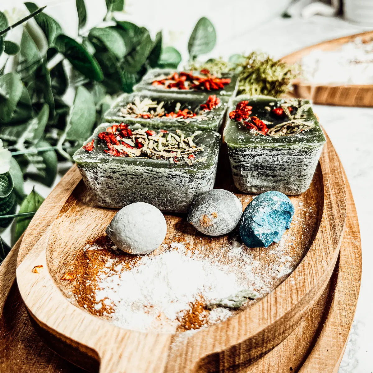 Green soap bars with herbs on a wooden board with a natural background