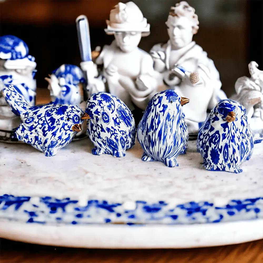 Blue and white ceramic birds on a decorative platter with classical statues in the background