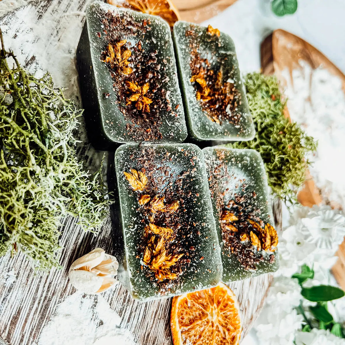 Green soap bars with orange pieces on a decorative background
